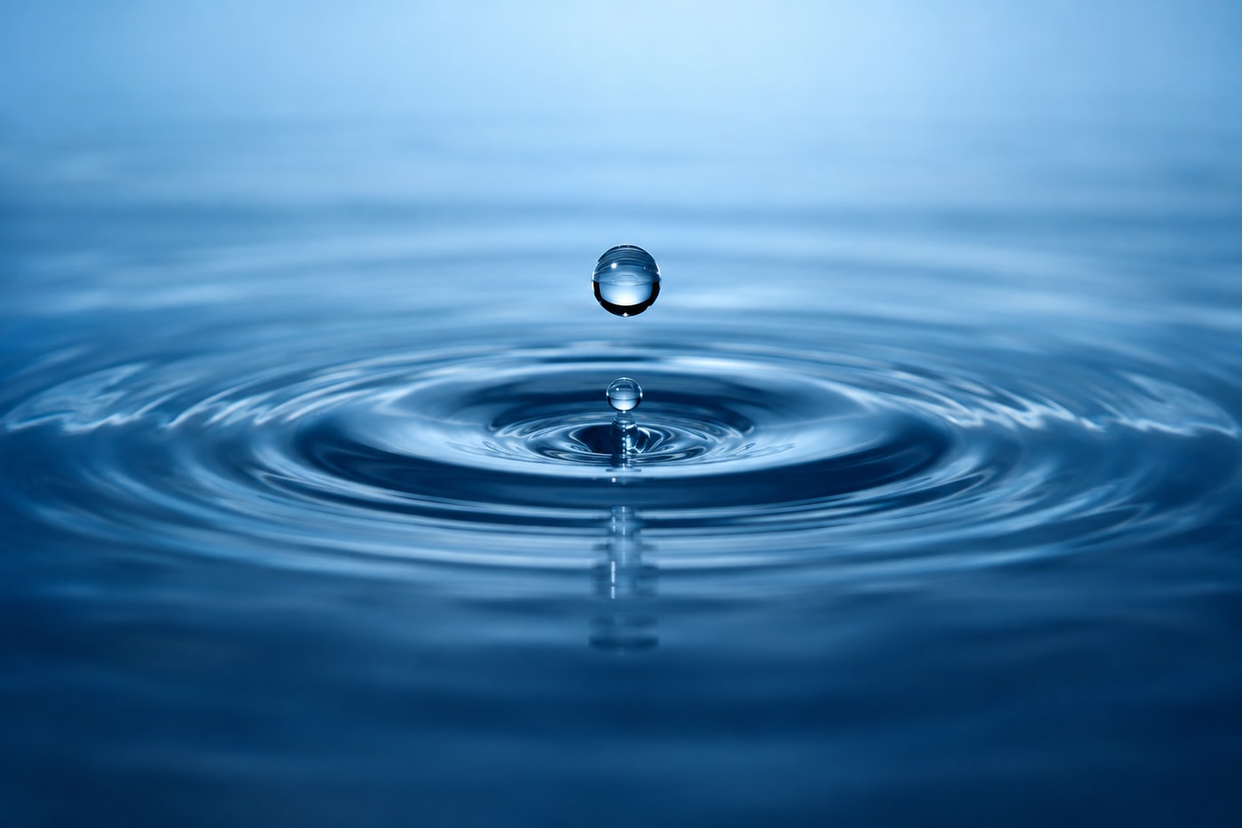 青い水面に落ちる水滴と波紋